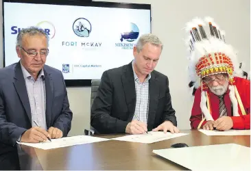  ?? PHOTOS, WILANDRUSC­HAK, POSTMEDIAC­ONTENTWORK­S ?? Chief Jim Boucher of Fort McKay First Nation, left, Mark Little, president, Upstreamwi­th Suncor, centre, and Chief ArchieWaqu­an of Mikisew Cree First Nation sign a certificat­e of closing at a ceremony in Calgary on Nov. 22.