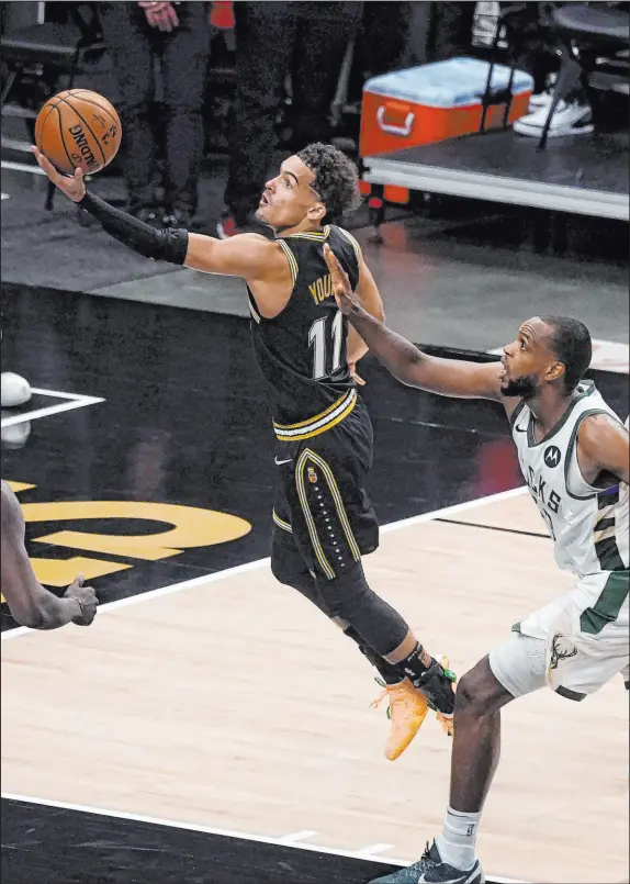  ?? John Bazemore The Associated Press ?? Dynamic point guard Trae Young, driving past Milwaukee’s Khris Middleton, was injured and missed two games in the conference finals.