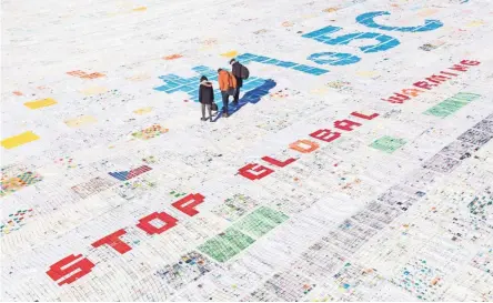  ??  ?? A giant postcard, with thousands of messages against climate change, is installed on the Aletsch glacier in Switzerlan­d.