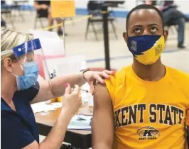  ?? AP PHOTO/PHIL LONG ?? Kent State University student Marz Anderson gets his Johnson & Johnson COVID-19 vaccinatio­n from Kent State nurse Beth Krul in Kent, Ohio, on Thursday.