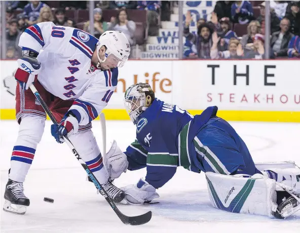  ?? — GETTY IMAGES) ?? Canucks goalie Jacob Markstrom stops J.T. Miller of the New York Rangers during the first period of Tuesday night’s game at Rogers Arena. Miller ended up scoring two goals, however, as the high-scoring Rangers routed the Canucks 7-2.