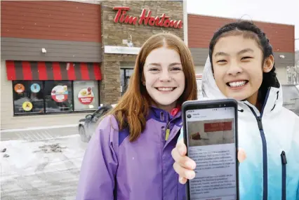  ?? THE CANADIAN PRESS/JEFF MCINTOSH ?? Mya Chau, right, 12, and Eve Helman, 12, who are digitally petitionin­g Tim Hortons to make the Roll Up the Rim to Win campaign more environmen­tally friendly, are seen outside a Tim Hortons in Calgary earlier this month.