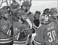  ??  ?? AP PHOTO
Carolina Hurricanes’ Elias Lindholm (28) and goalie Cam Ward celebrate with teammates following Lindholm’s game-winning goal in overtime against the Tampa Bay Lightning in Raleigh, N.C., Saturday.