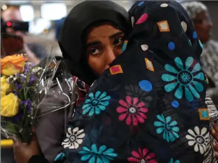  ?? WIN MCNAMEE, GETTY IMAGES ?? Roodo Abdishakur, left, hugs her mother Zahra Warsma after arriving from Somalia at Dulles Internatio­nal Airport on Monday in Washington, D.C. Abdishakur and her sisters were prohibited from entering the U.S. a week ago due to Donald Trump’s tightened...