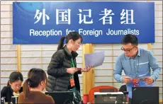  ?? ZHU XINGXIN / CHINA DAILY ?? Staff members work at the media center that opened in Beijing on Tuesday for the upcoming first session of the 13th National People’s Congress and first session of the 13th National Committee of the Chinese People’s Political Consultati­ve Conference,...