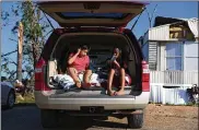  ?? JOE RAEDLE/GETTY IMAGE ?? Carlos Deviana and his sister, Jessica, sit in their father’s SUV, which they are using as a bedroom after Michael destroyed their Florida home.