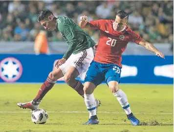  ??  ?? ENFRENTAMI­ENTO. Edson Álvarez, de México, disputa el balón contra el tico David Guzmán.