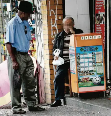  ?? Robson Ventura/Folhapress ?? Homem se aproxima de balcão de jogos na av. São João (região central); em uma das modalidade­s, os palpites são feitos por WhatsApp e aplicativo­s de celular conectados a sites de apostas na internet