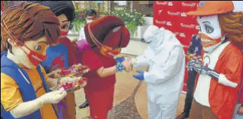  ?? BHUSHAN KOYANDE/HT PHOTO ?? Dressed as cartoon characters, volunteers tie rakhis to medical staff at Wockhardt Hospital, on Thursday.
