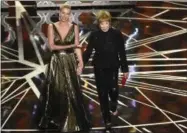  ??  ?? Charlize Theron, left, and Shirley MacLaine present the award for best foreign language film at the Oscars on Sunday, at the Dolby Theatre in Los Angeles.