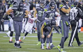  ?? TED S. WARREN/THE ASSOCIATED PRESS ?? Seahawks kicker Blair Walsh, center, gets a pat from Josh Forrest after Walsh missed a 52-yard attempt with 2 seconds left.