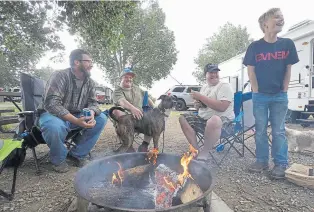  ?? Jenny Sparks, Loveland Reporter-Herald file ?? Above: From left: Josh Bryant, Garrett Crawford, Jacob Doolittle and Jayden Bryant laugh around a campfire at Boyd Lake State Park in Loveland in 2018.