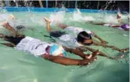  ??  ?? Young children take part in a swimming lesson in Dhaka. Earlier this year, the Bangladesh government announced it would make it mandatory for all schoolchil­dren to learn to swim.