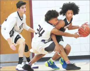  ?? Photo by Ernest A. Brown ?? Central Falls wing Dutchie Arroyo (right) attempts to hold off a pair of St. Raphael defenders during the Saints’ Donaldson-Lynch tournament semifinal victory Thursday night in Pawtucket.