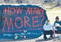  ?? DETROIT NEWS ?? Michigan State University students place flowers at “The Rock” on the East Lansing campus on Tuesday.