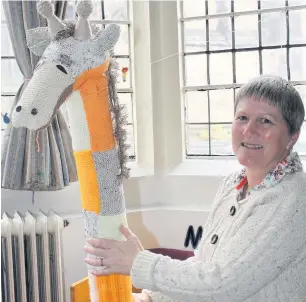  ??  ?? ●●Jane Roughley with knitted giraffe prepares for the St George’s festival