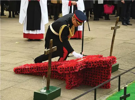  ??  ?? The Duke of Sussex places a cross on a memorial at the Field of Remembranc­e at Westminste­r Abbey