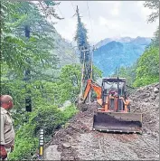  ?? AQIL KHAN /HT ?? An earthmovin­g machine clearing debris from a road after a cloudburst in the Parvati Valley of Kullu district on Thursday.