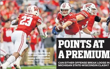  ?? [ANDY MANIS/THE ASSOCIATED PRESS] ?? Wisconsin quarterbac­k Jack Coan hands off to running back Jonathan Taylor.