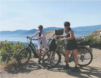  ??  ?? Writer Jane Mundy, left, says an electric bike is the perfect vehicle for exploring the vistas of Penticton.