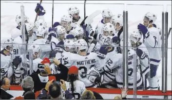  ?? Kamil Krzaczynsk­i The Associated Press ?? Maple Leafs defenseman Morgan Rielly is somewhere in a mob of happy teammates after scoring the OT winner in a 7-6 decision against the Blackhawks on Oct. 7.