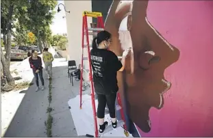  ?? A STUDENT Al Seib Los Angeles Times ?? paints a mural on a Highland Park storefront in support of Black Lives Matter.