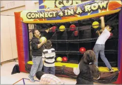  ?? RACHEL RICE / LAKE TRAVIS VIEW ?? Hutto resident Robert Coy helps foster children retrieve balls out of an inflatable game board during the Lakeway/Lake Travis Rotary Club adoption event at Lakeway Church on March 4.