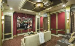  ?? ?? For a home theater project in Orlando, Florida, John McClain upholstere­d portions of the walls with red velvet inside of wooden accent panels. Champagne-hued velvet seating completes the look.