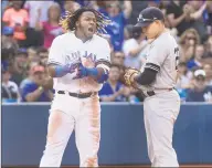  ?? Fred Thornhill / Associated Press ?? Toronto Blue Jays’ Vladimir Guerrero Jr. celebrates his tworun triple, next to New York Yankees’ Gio Ushela, during the seventh inning in Toronto on Saturday. The Blue Jays won 54.