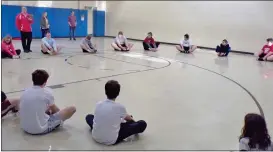  ?? BOB KEELER — MEDIANEWS GROUP ?? Indian Creek Foundation Therapeuti­c After School Program and Souderton Area High School football team members sit in a circle for exercises together.