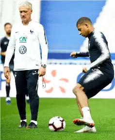  ??  ?? Mbappe (right) plays the ball in front Didier Deschamps during a training session at the Stade de France stadium in Saint-Denis, north of Paris. — AFP photo