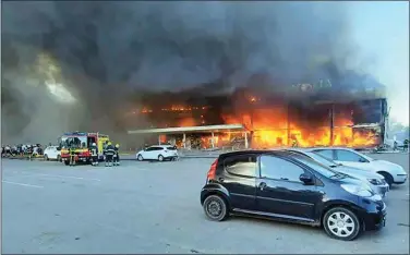  ?? UKRAINIAN STATE EMERGENCY SERVICE VIA AP ?? In this image made from video provided by Ukrainian State Emergency Service, firefighte­rs work to extinguish a fire at a shopping center burned after a rocket attack in Kremenchuk, Ukraine on Monday.