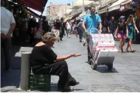 ??  ?? A WOMAN BEGS in Jerusalem.