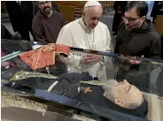  ?? — AFP ?? ( Right) Pope Francis prays before a display case holding St. Padre Pio’ body in a shrine town, in Italy on Saturday.