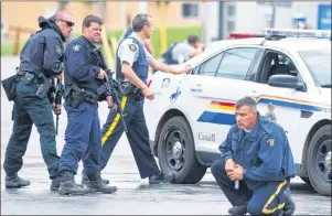  ?? CP PHOTO ?? Police keep watch on a house as they search for a heavily armed gunman following the shooting of three Mounties in Moncton, N.B., on June 5, 2014. The RCMP was fined $550,000 Friday for Labour Code violations in the 2014 Moncton, N.B., shooting rampage...