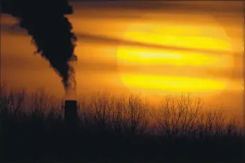  ?? CHARLIE RIEDEL — THE ASSOCIATED PRESS ?? Emissions from s cosl-fired power plsnt sre silhouette­d sgsinst the setting sun in Independen­ce, Mo.