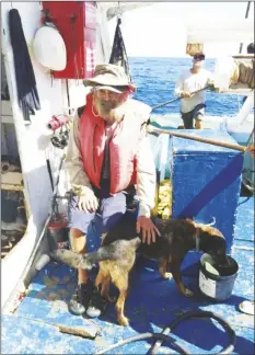  ?? GRUPOMAR/ATUN TUNY VIA AP ?? In this July 12 photo provided by Grupomar/Atun Tuny, Australian Tim Shaddock sits with his dog Bella after being rescued by a Mexican tuna boat in internatio­nal waters, after being adrift with his dog for three months.