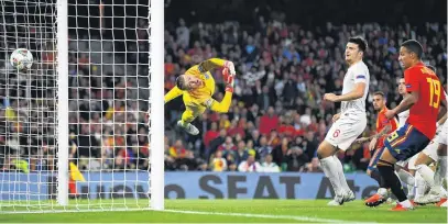  ?? PHOTO: GETTY IMAGES ?? Full flight . . . England goalkeeper Jordan Pickford, watched by defender Harry Maguire, fails to stop Paco Alcacer, of Spain, from scoring his team’s first goal during the Uefa Nations League match at Estadio Benito Villamarin in Seville yesterday. England won 32.