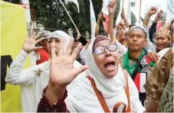  ?? — AP ?? JAKARTA: Muslim protesters shout slogans during a protest against Jakarta’s Christian Governor Basuki ‘Ahok’ Tjahaja Purnama outside a court where his trial is held in Jakarta yesterday.