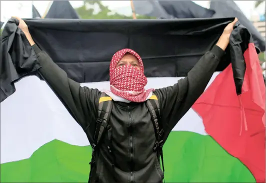  ?? Picture: REUTERS ?? UNFLAGGING: A demonstrat­or holds a mock-up of the Palestinia­n flag during a protest to condemn Washington’s decision to recognise Jerusalem as Israel’s capital, outside the US embassy in Jakarta, Indonesia, yesterday.