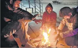  ?? WASEEM ANDRABI/HT ?? Locals warm themselves on a chilly evening in Srinagar.