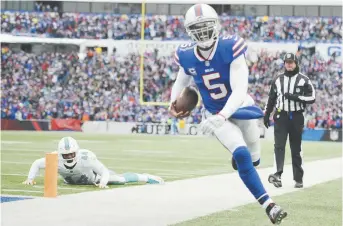  ??  ?? Le quart arrière des Bills de Buffalo, Tyrod Taylor (5), termine sa course avec un touché, lors d’un match contre les Dolphins de Miami, dimanche. - Associated Press: Adrian Kraus