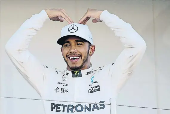  ?? FOTOS: AP/GETTY ?? Lewis Hamilton homenajeó al fondista Mo Farah, presente ayer en el box de Mercedes durante la carrera, imitando el gesto con el que el atleta celebra sus triunfos (arriba). Partiendo desde la pole position (izquierda), Hamilton supo dominar la carrera para cruzar la meta (derecha) antes que nadie