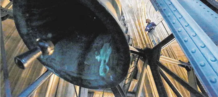  ?? FOTOS: DPA ?? Arbeitspla­tz in luftiger Höhe: Der Glockensac­hverständi­ge Norbert Jachtmann steht mit Kopfhörern im Dom und betrachtet eine schwingend­e Glocke.