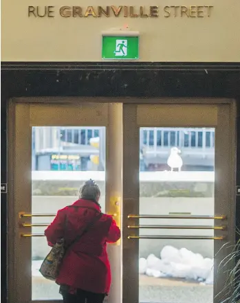  ?? ARLEN REDEKOP ?? In British Columbia, the traditiona­l red exit sign will be disappeari­ng in favour of a green pictogram, as seen above the door of the Sinclair Centre in Vancouver. In the interim, some buildings will have both signs.