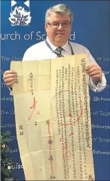  ??  ?? HISTORIC: Sandy Sneddon, Asia secretary of the Church of Scotland’s World Mission Council holding the fragile handwritte­n public proclamati­on.