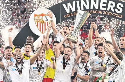  ?? AFP ?? Sevilla players celebrate with the trophy after winning the Europa League final at the Puskas Arena in Budapest.