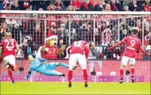  ?? GUENTER SCHIFFMANN/AFP ?? Robert Lewandowsk­i (right) scores Bayern’s third goal from the penalty spot in their Bundesliga match against RB Leipzig in Munich on Wednesday.