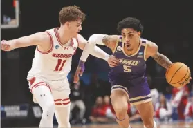  ?? MARY ALTAFFER/AP ?? JAMES MADISON GUARD TERRENCE EDWARDS JR. (5) drives against Wisconsin guard Max Klesmit (11) during the second half of a first-round game in the Tournament on Friday in New York.