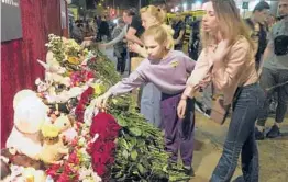  ?? DMITRI LOVETSKY/AP ?? Mourners leave flowers Tuesday near a school after a mass shooting in Kazan, Russia. Officials said the attacker, identified only as a 19-year-old man, was arrested.
